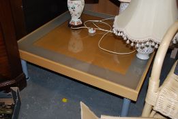 A contemporary large beech wood and glass coffee table of square form having inset glass top to