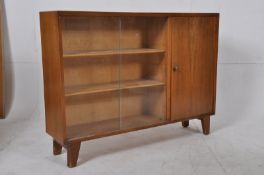 A 1940`s walnut library bookcase display cabinet. Raised on square legs with sliding glass doors