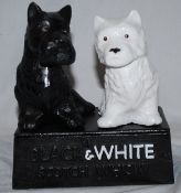 A vintage style cast metal advertising statue for Black & White Whiskey, featuring the two famous