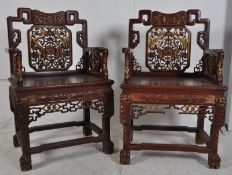 A pair of 20th century Chinese hardwood elbow chairs. Pierced and carved scrolls with gilt edge