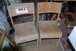 2 metal stacking chairs with wooden seats and wooden backrests