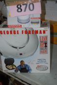 A boxed George Foreman Lean Mean Fat Grilling Machine, along with a Tefal Le Saucier.