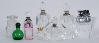 A selection of scent bottles mainly crystal glass along with a table top cigarette lighter