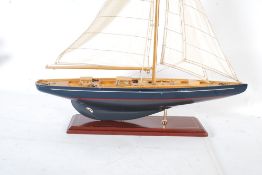 A large 20th century wooden constructed toy model pond yacht boat. On stand with fully rigged sails