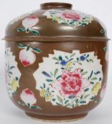 An 18th century brown glazed oriental Chinese bowl with lid, being hand painted with flowers set