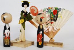 A Japanese advertisiting figurine on wooden plinth with fan.
