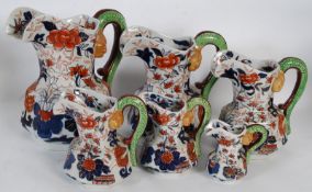 A graduating set of 6 Ironstone hydra shaped jugs having floral decoration in deep reds and blues