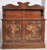 A Victorian bone inlaid carved oak pier cabinet. The plinth base supporting a twin door cupboard