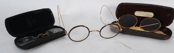 A pair of vintage tortoiseshell rimmed glasses with sun glass covers together with a pair of pinz