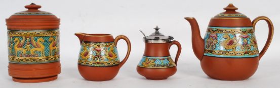 Four items of terracotta Pratt Ware decorated showing Griffins, consist of teapot, cream jug, honey