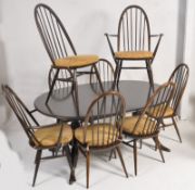 An Ercol large extending beech and elm dining table together with a matching set of 8 dining chairs,