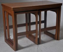 A 1970's retro teak nest of table. Raised on shaped supports having twin tables underneath,the