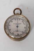 A brass cased pocket barometer. Probabley made by F Barker and son Marked for the retailer J
