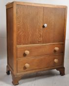 A 1930's oak tall boy chest of drawers. Linen cupboard over drawers all raised on bracket feet.