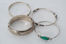 A collection of four white metal silver bracelets, three being marked for silver, the other silver