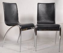 A pair of contemporary faux leather and chrome dining chairs. Angled cantilever style frames