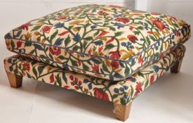 A large chenille upholstered footstool. Raised on tapered legs with an oversized frame having