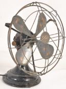 An early 20th Century GEC metal table top fan, Sat on a terraced base having original wire guard