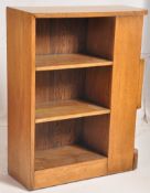 A 1930's Art Deco oak bookcase cabinet. The plinth base having open window bookcase sections with