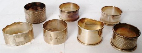 Three silver hallmarked napkin rings along with four silver plate napkin rings.