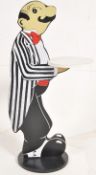 A decorative wooden dumb waiter in the form of a butler in side profile