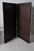 A large twin section folding screen. Panelled wood with hinged centre