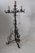 A vintage wrought iron three prong ebonised standard lamp