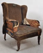 A Victorian mahogany wingback armchair. For reupholstery, the chair stands on mahogany legs with