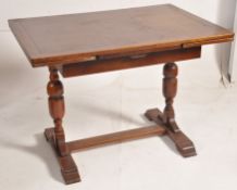 A 1930's oak draw leaf refectory dining table. Raised on cup and cover legs united by stretcher