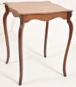 An Edwardian mahogany occasional table raised on sabre reeded shaped legs with fitted frieze