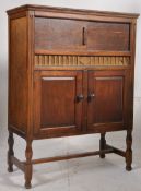 A 1930's oak tall gramaphone cabinet raised on shaped supports. Twin door cupboard under a hinged