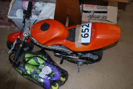 A mini moped in orange, also includes a bair of roller blades.