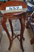 A vintage carved wooden plant stand with pierced carving design to base of plate standing on