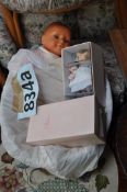 A toy baby doll in crib / basket along with 2 boxed Paulinettes dolls.
