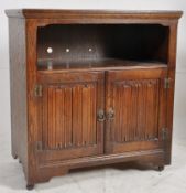 A Jacobean revival oak side cabinet / record cabinet. The cupboard with linen fold doors enclosing