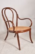 An early 20th century Thonet bentwood caned armchair. Turned and splayed legs with caned seat having