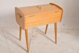 A good 1970's beechwood folding top sewing box being raised on tapered legs with handle atop and