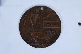 A World War One death plaque awarded to Tom Watts. Measures 12cms in diameter