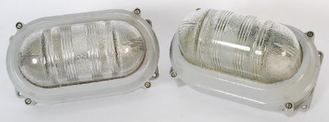 A pair of Industrial metal and frosted glass wall lights, both stamped for Coughtrie of Glasgow,