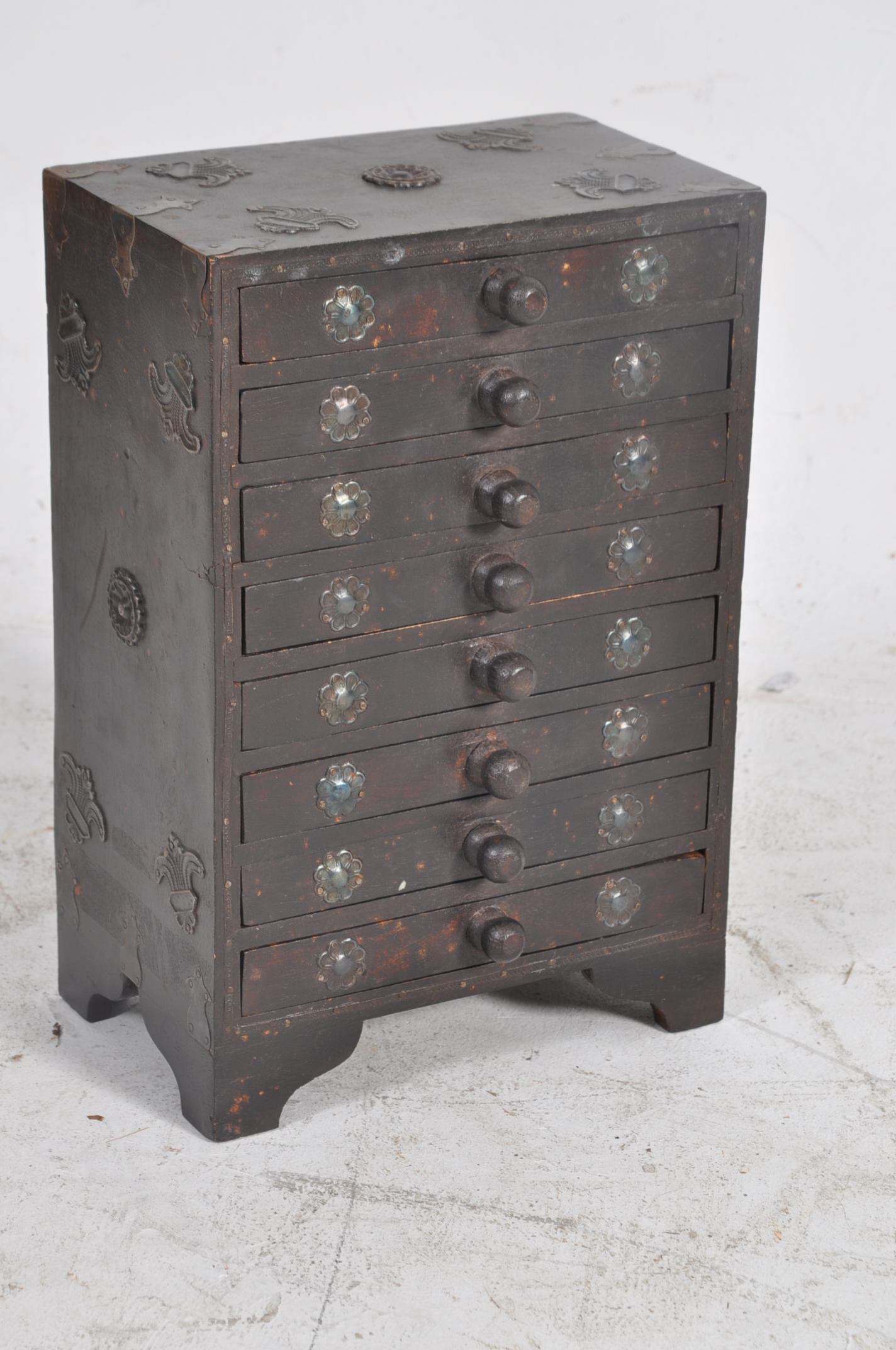 An Arts & Crafts style apprentice piece chest of drawers. Heavily embellished with white metal