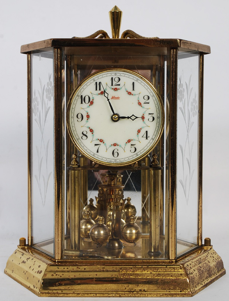 A Kundo anniversary clock set within dome having an enamel face