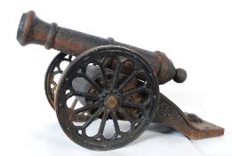 A 20th century Eastern cast iron decorative cannon. The barrels with cast flowing tendril designs on