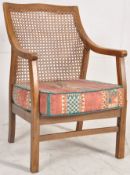 A 1930's Art Deco bergere armchair. Chintz cushion with caned back rest and sides, all raised on