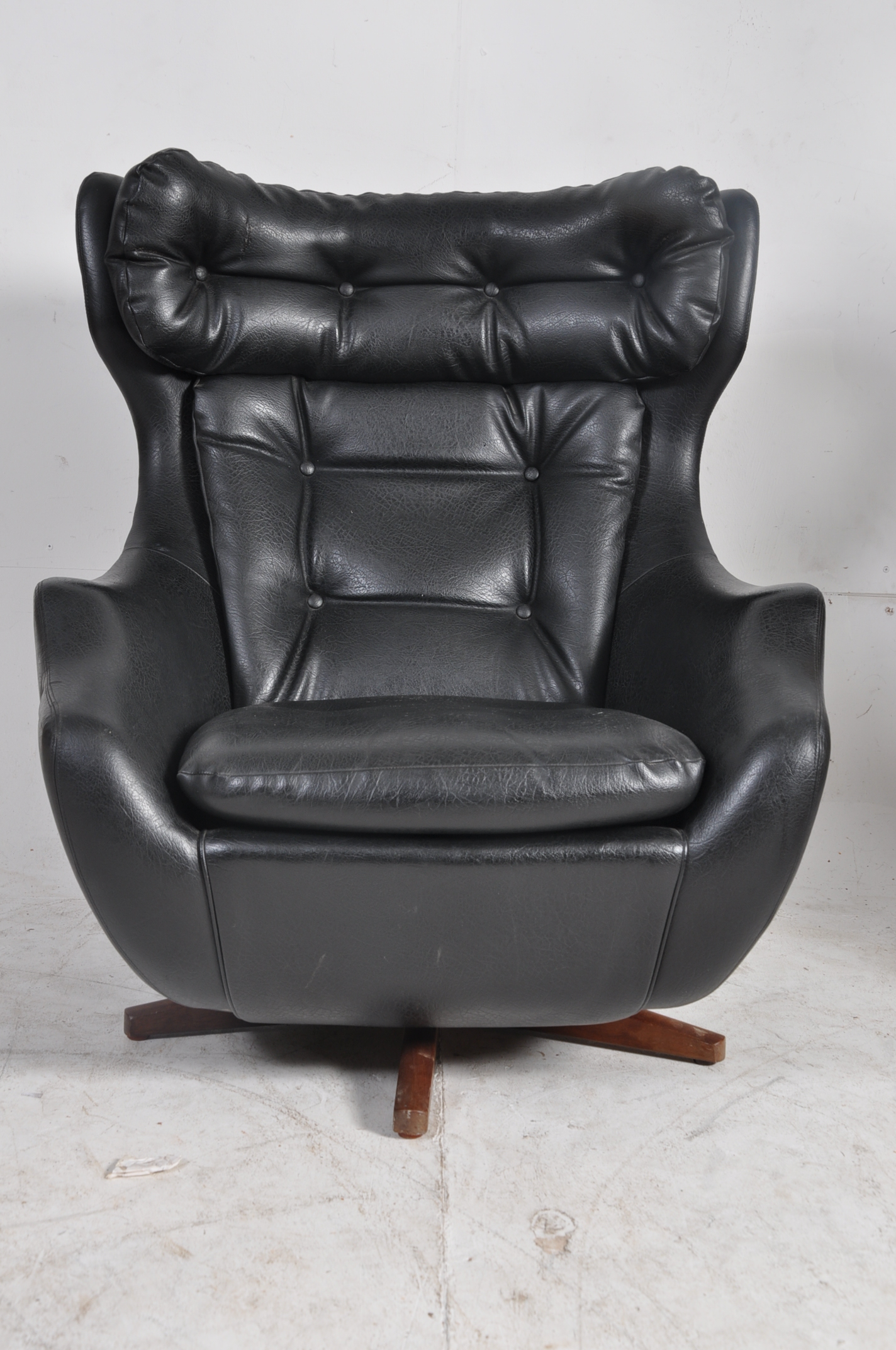 A good original 1970's Parker Knoll batwing faux leather armchair on swivel base. The quadruped