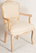 A contemporary French Fauteuil bedroom armchair. The beech wood frame having overstuffed cream