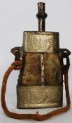 An antique North African shooting powder flask. Of horn construction with pressed brass decorated