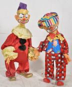 A pair of vintage part plaster clown  circus statues complete with clothing having painted faces,