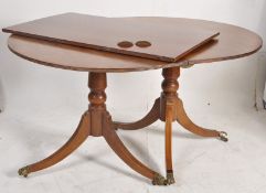 A Georgian revival solid mahogany twin pedestal dining table having single leaf with brass castors