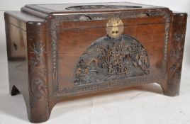 A large 1950's Chinese camphor blanket box / trunk. The shaped body heavily carved with detailed