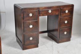 A 1930's Art Deco oak and simulated rosewood twin pedestal desk. The pedestals having a series of